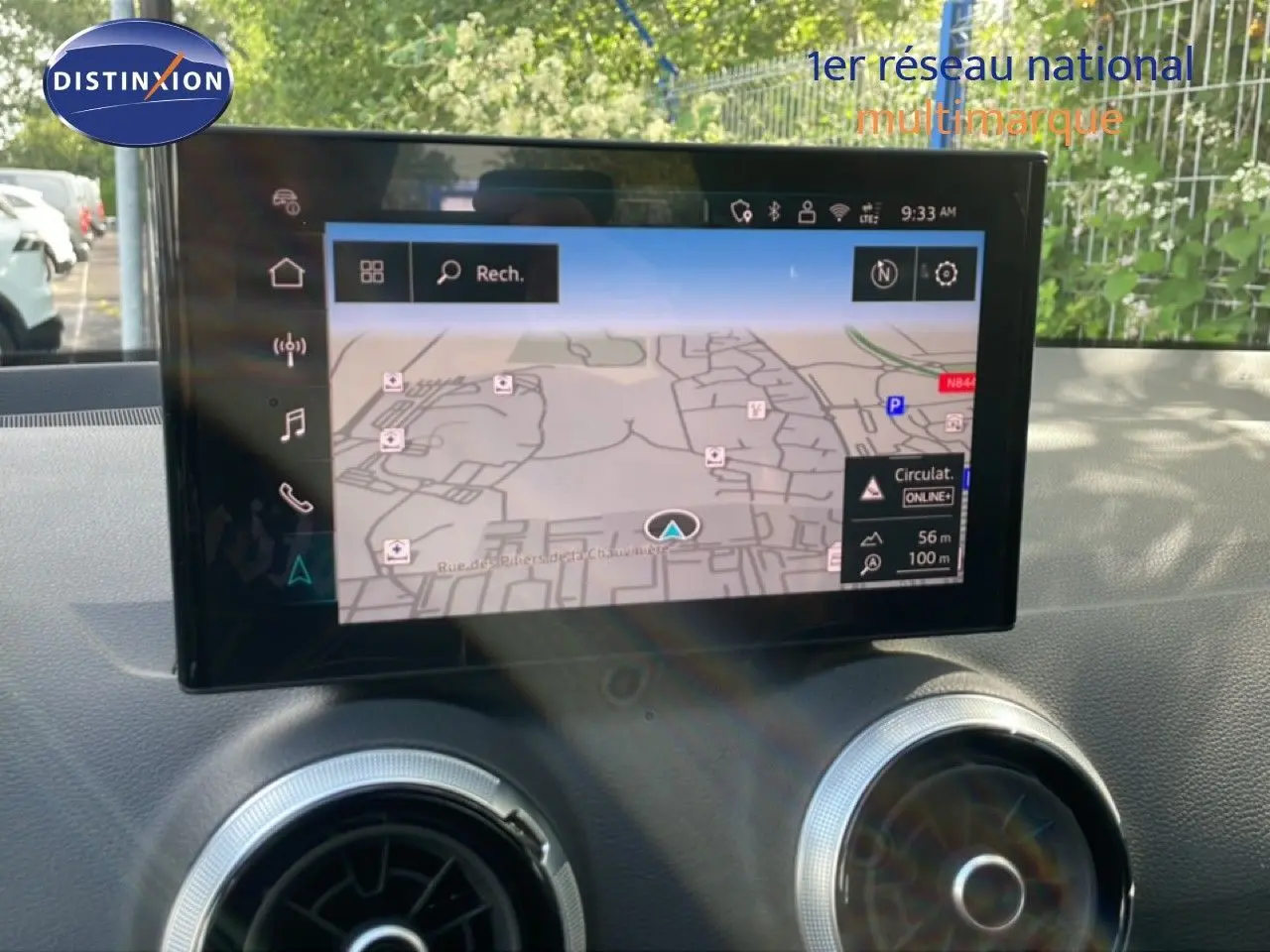 Écran tactile central affichant la navigation dans l'Audi Q2 30 TDI S-Line 2025, intérieur noir avec aérateurs ronds argentés.