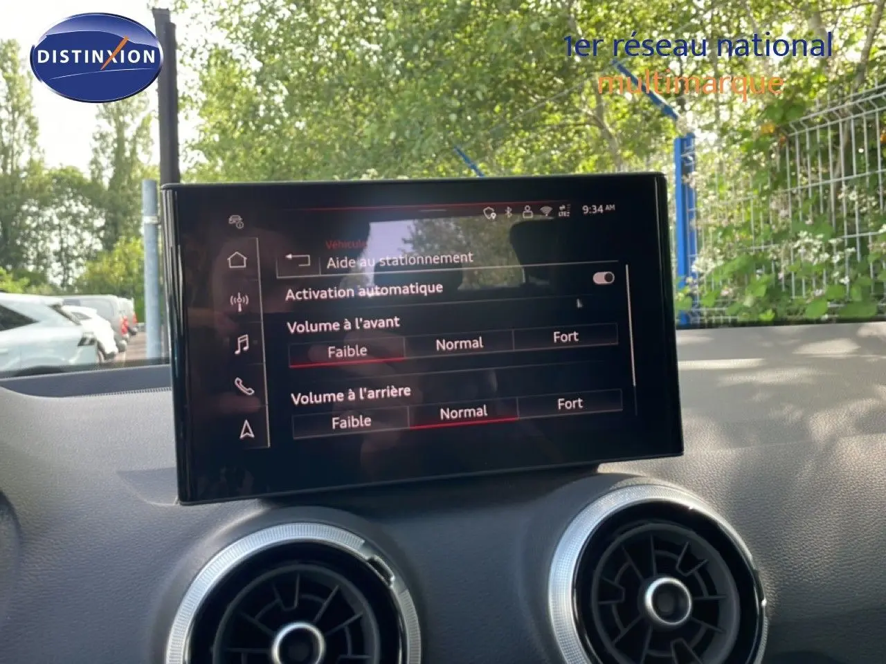 Écran central tactile affichant les réglages d'aide au stationnement dans l'habitacle d'une Audi Q2 gris Manhattan.