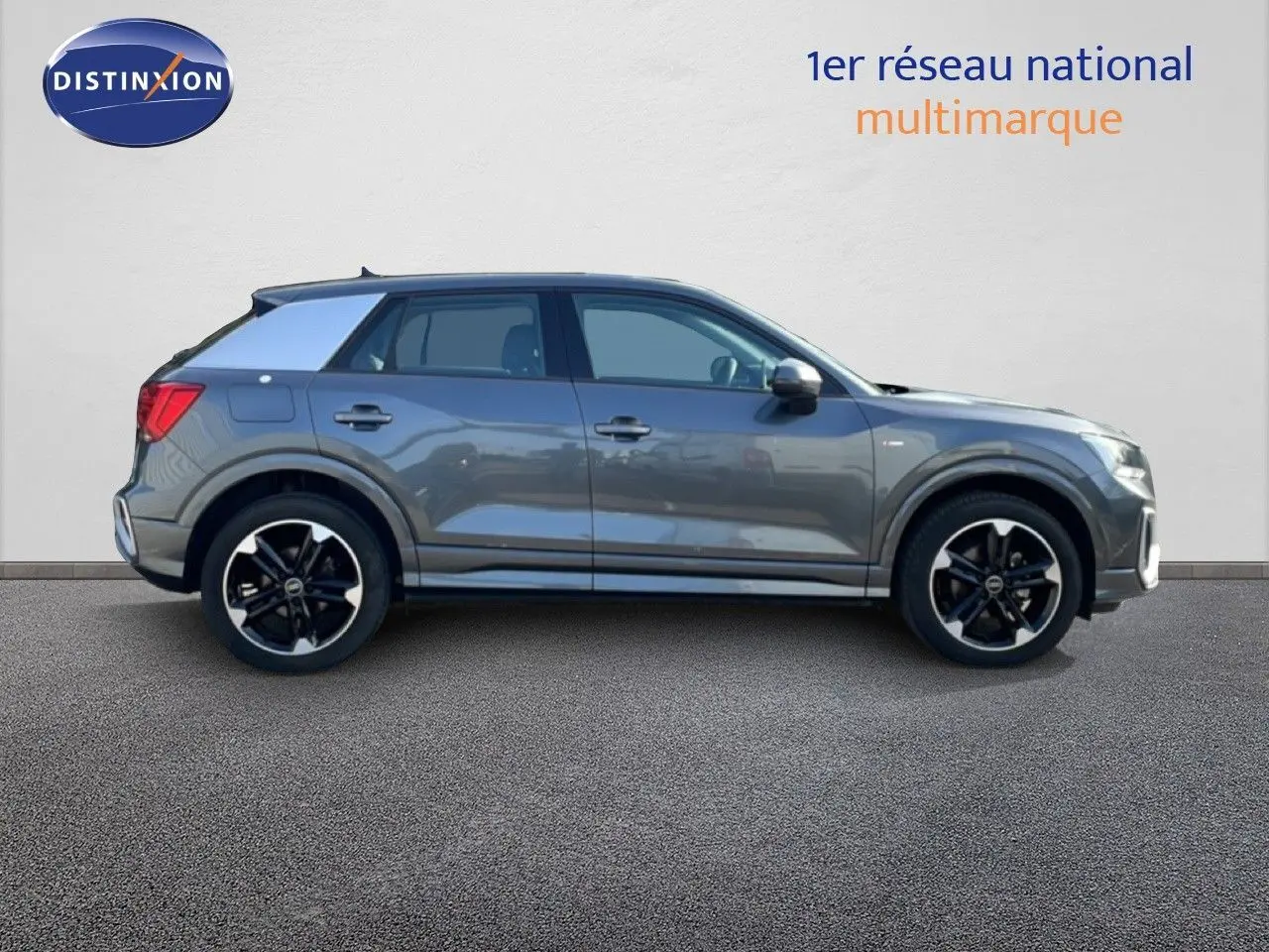 Audi Q2 30 TDI S-Line gris Manhattan vu de profil côté gauche, avec jantes noires et toit contrasté blanc.