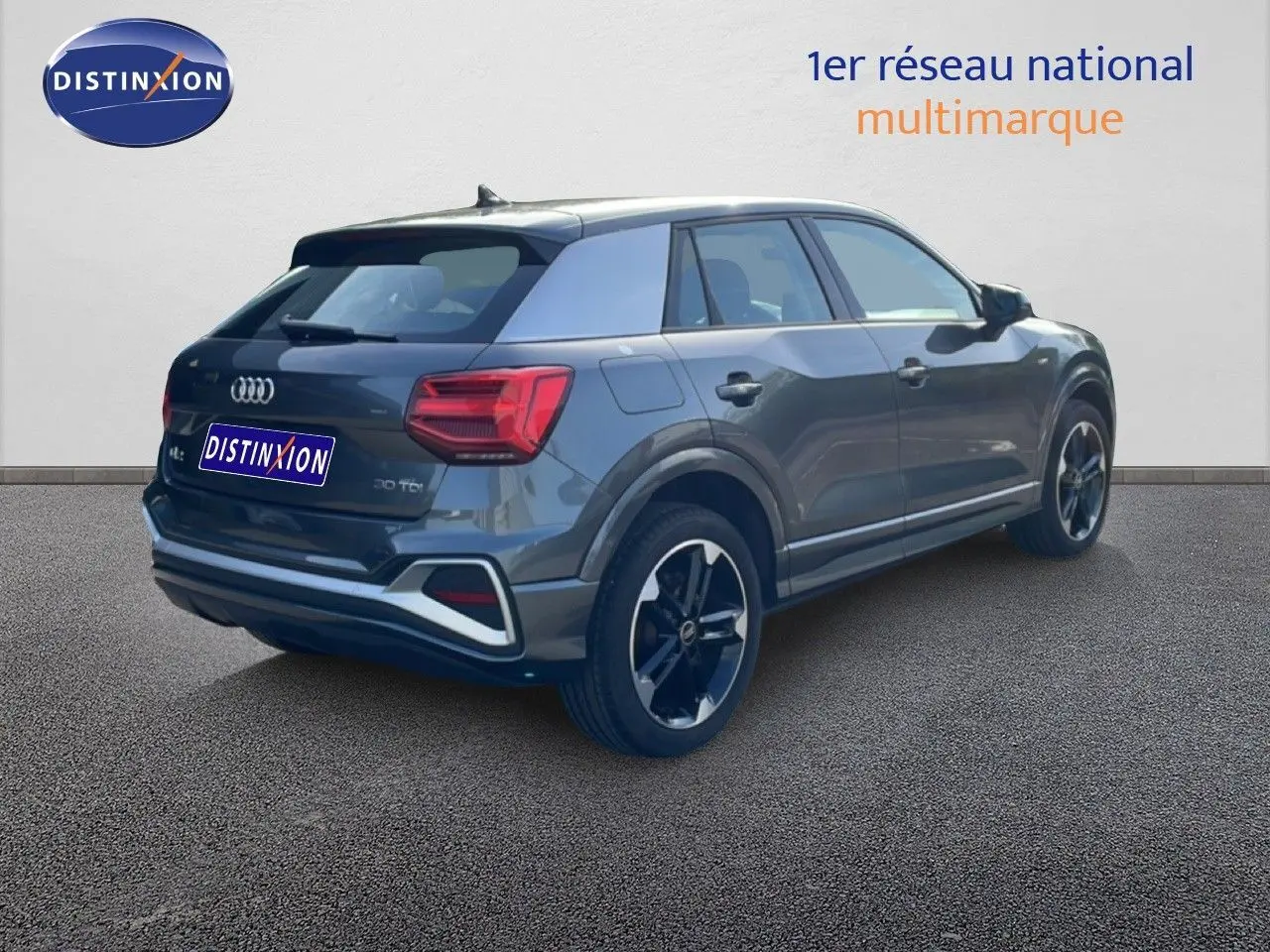 Audi Q2 30 TDI S-Line gris Manhattan, vue 3/4 arrière droit, avec jantes noires et feux LED distinctifs.