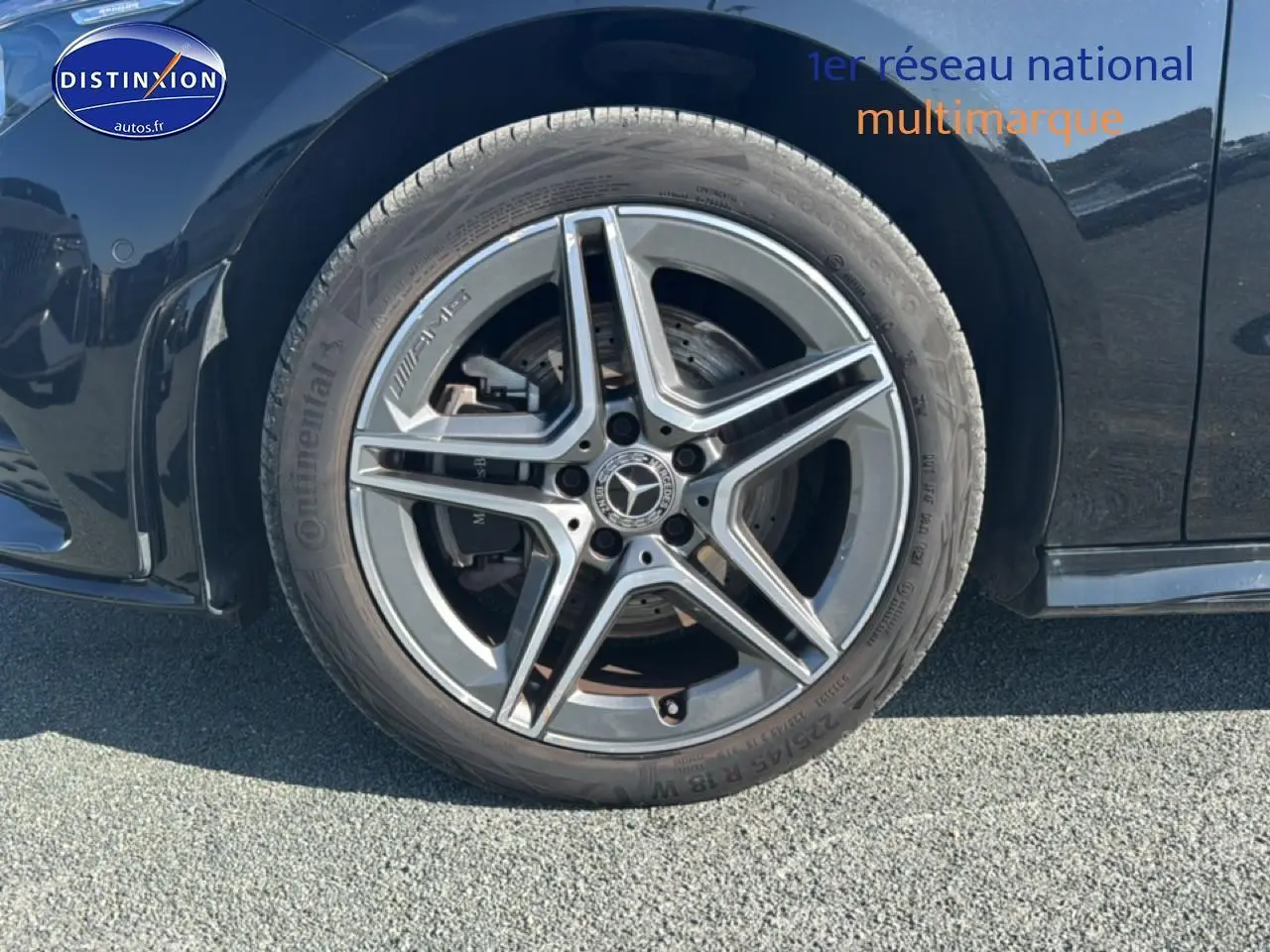Gros plan sur la roue avant gauche noire d'une Mercedes Classe CLA 250 e AMG Line avec jante alu cinq branches.