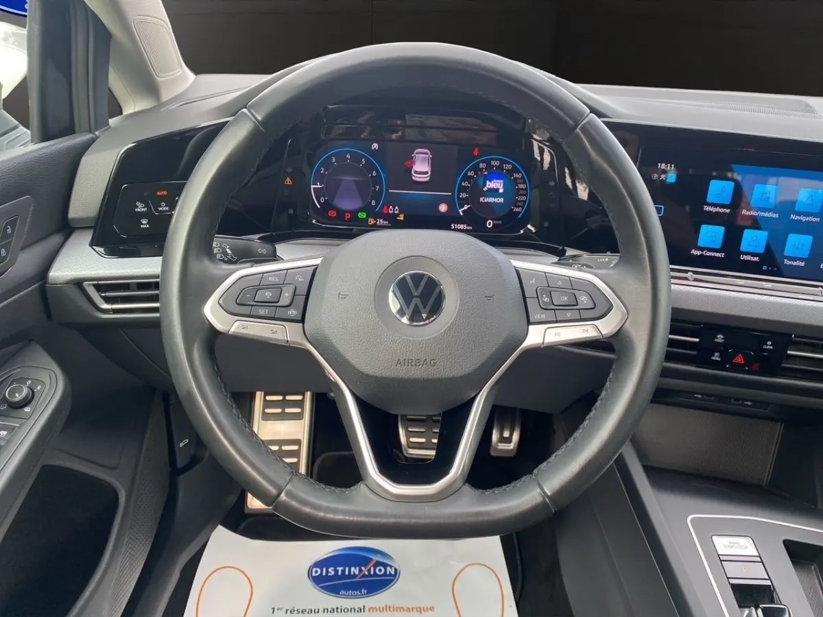 Vue intérieure centrée sur le volant cuir multifonctions et le tableau de bord numérique de la Volkswagen Golf 2022.