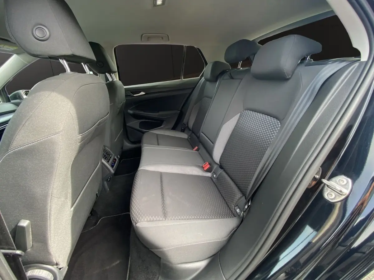 Vue intérieure côté droit sur la banquette arrière noire avec vitres arrière surteintées d'une Volkswagen Golf 2022.