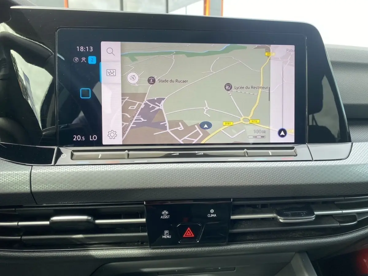 Écran tactile de navigation 10 pouces sur tableau de bord gris clair de Volkswagen Golf noire, vue frontale rapprochée.