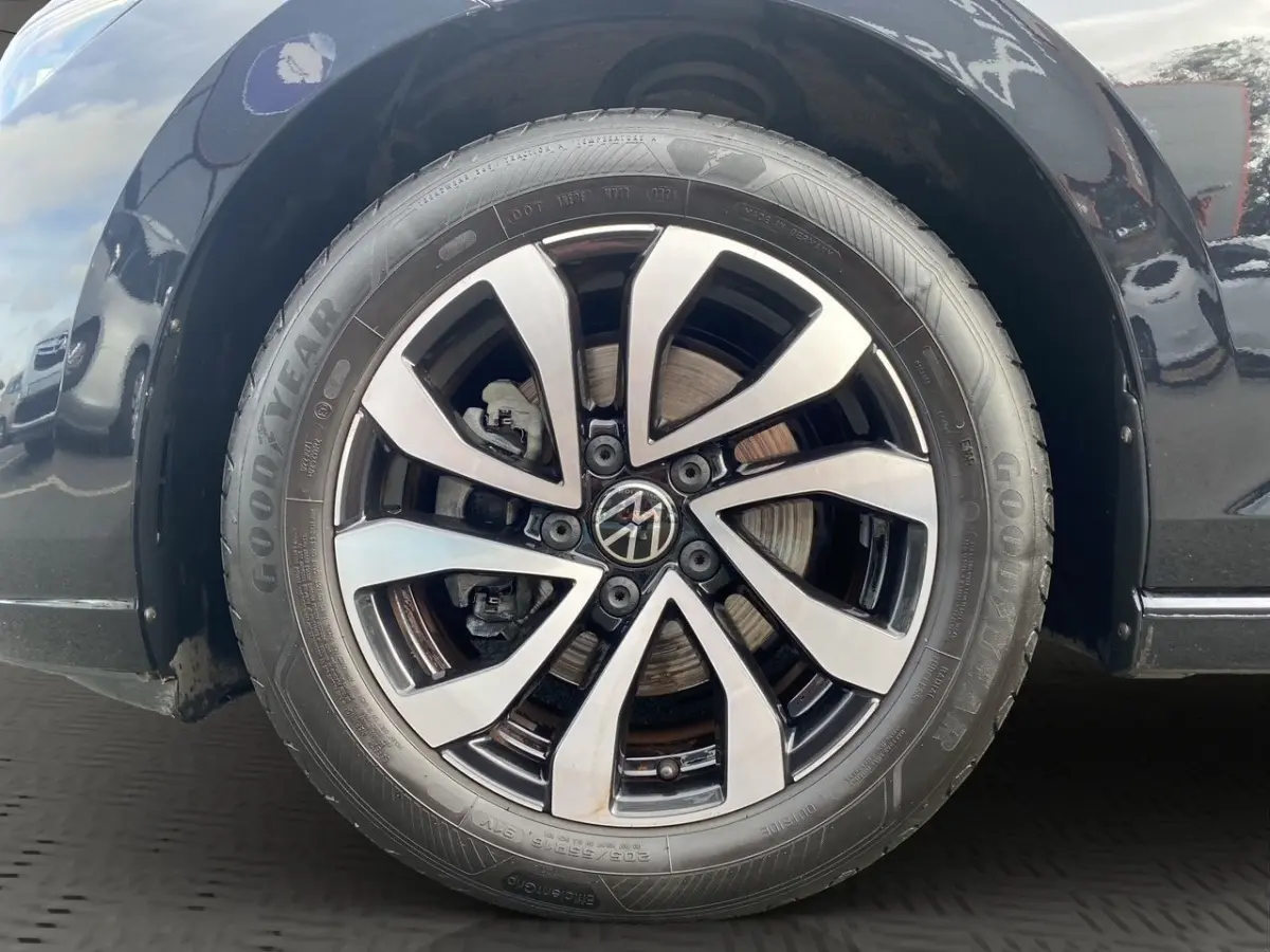 Gros plan sur la roue avant droite noire d'une Volkswagen Golf 1.0 eTSI avec jante alliage bicolore et pneu Goodyear.
