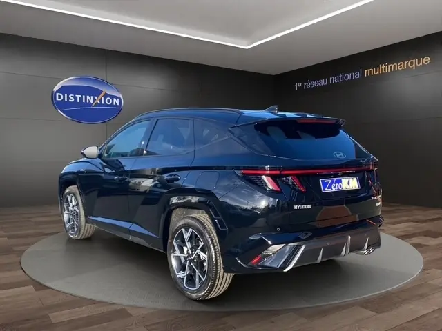 Vue 3/4 arrière droite du Hyundai Tucson noir 2026 avec hayon motorisé et feux arrière LED étirés.