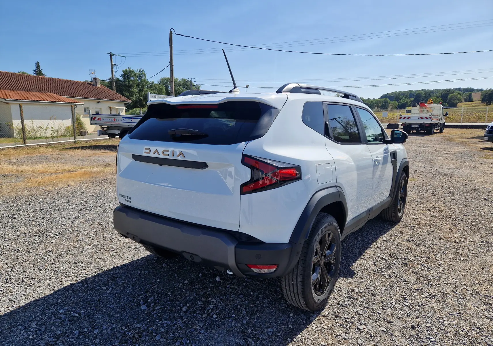 Vue 3/4 arrière droite du Dacia Duster blanc 2026, soulignant ses jantes noires et ses feux arrière modernes.