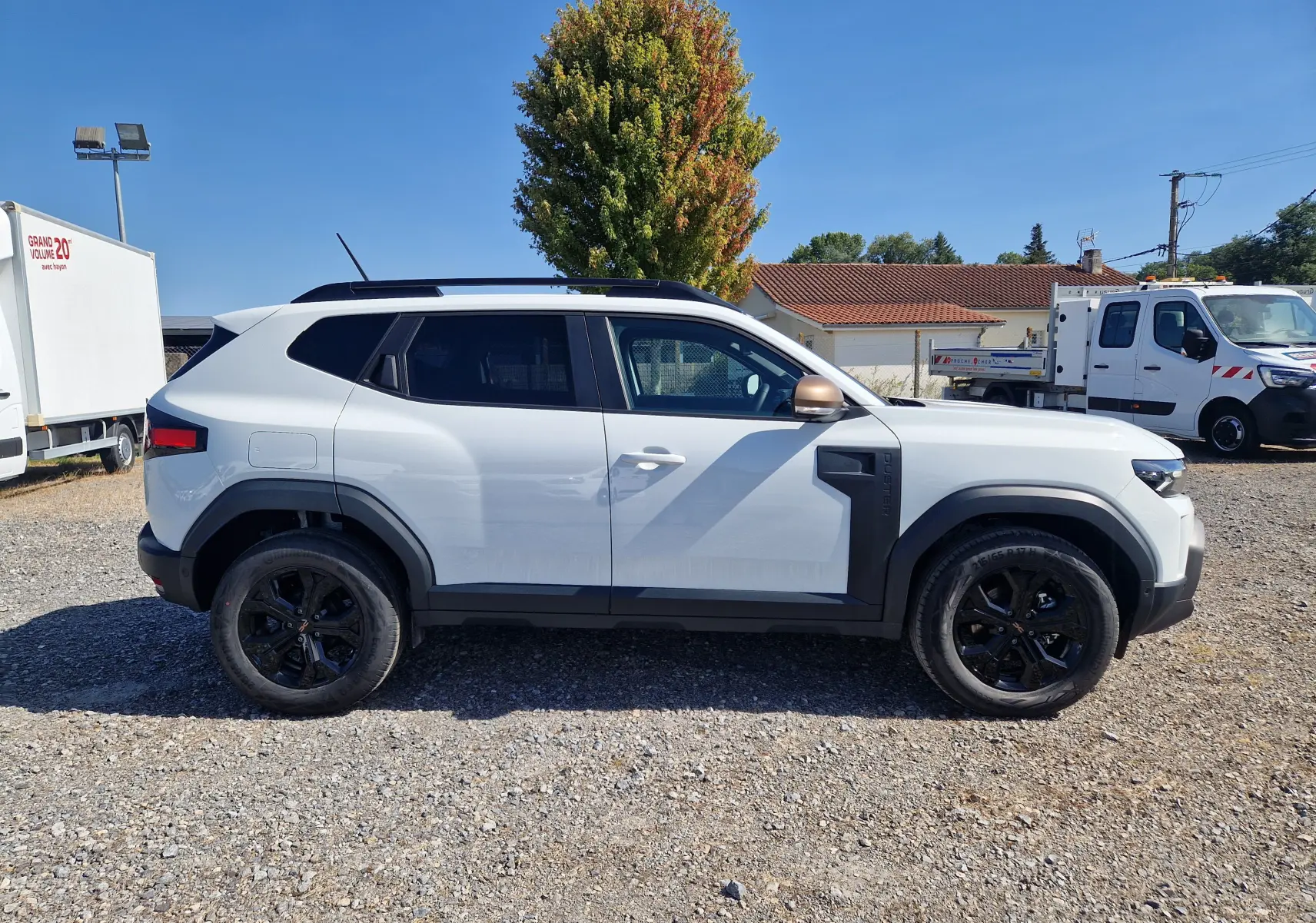 Profil droit du Dacia Duster blanc 2026 avec jantes noires et détails noirs contrastants sur les ailes et rétroviseurs.