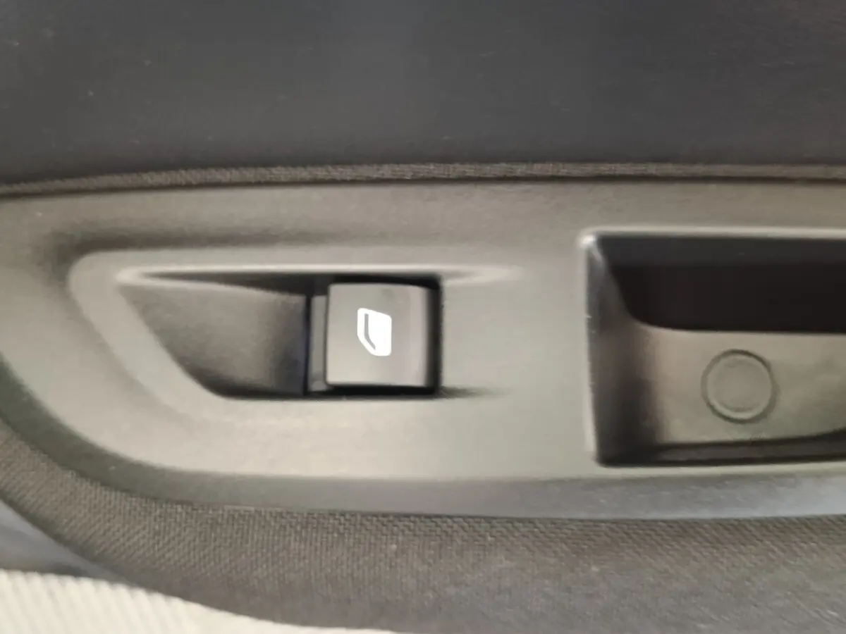 Bouton de commande de verrouillage des portes sur la portière intérieure d'une Peugeot E-2008 électrique gris clair.