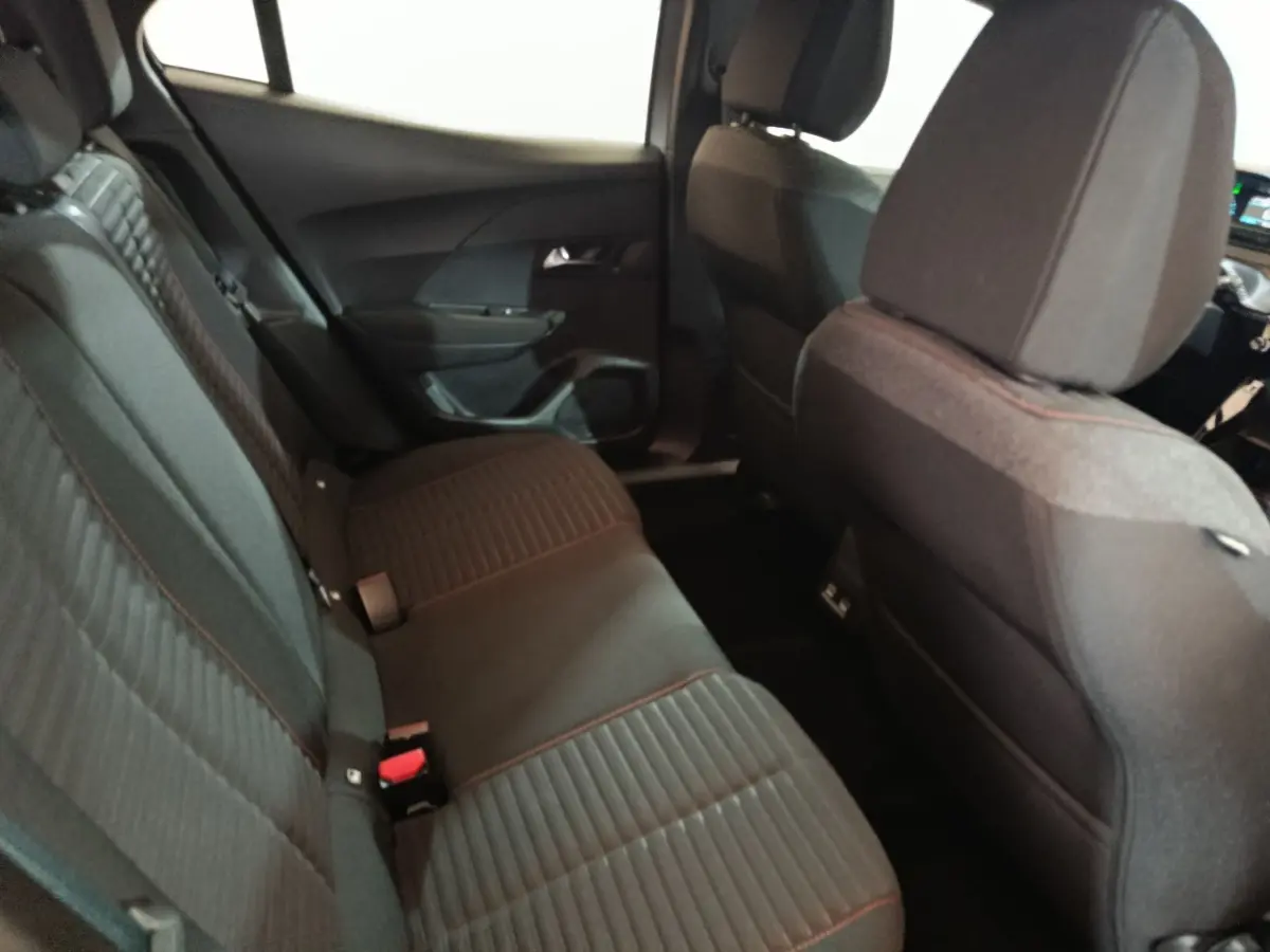 Vue intérieure côté gauche sur la banquette arrière noire avec surpiqûres rouges du Peugeot E-2008 électrique 2023.
