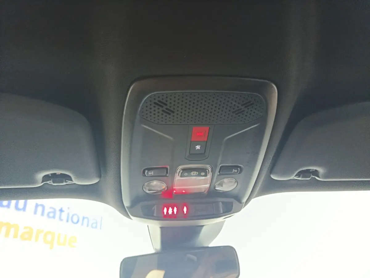 Vue intérieure du plafonnier avec commandes d’éclairage et bouton SOS du Peugeot E-2008 électrique gris clair 2023.
