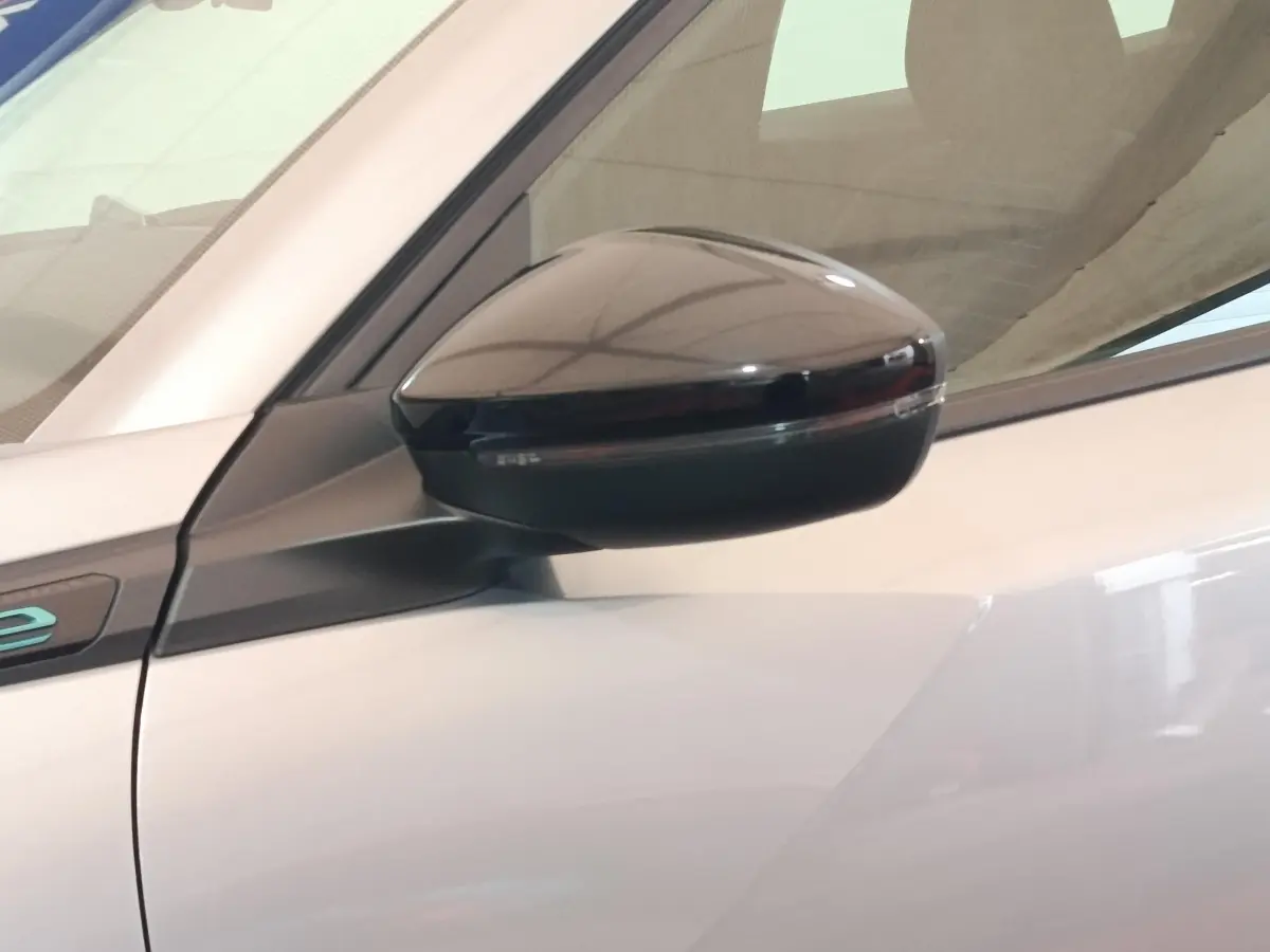 Gros plan sur le rétroviseur côté gauche noir brillant du Peugeot E-2008 électrique gris clair 2023.