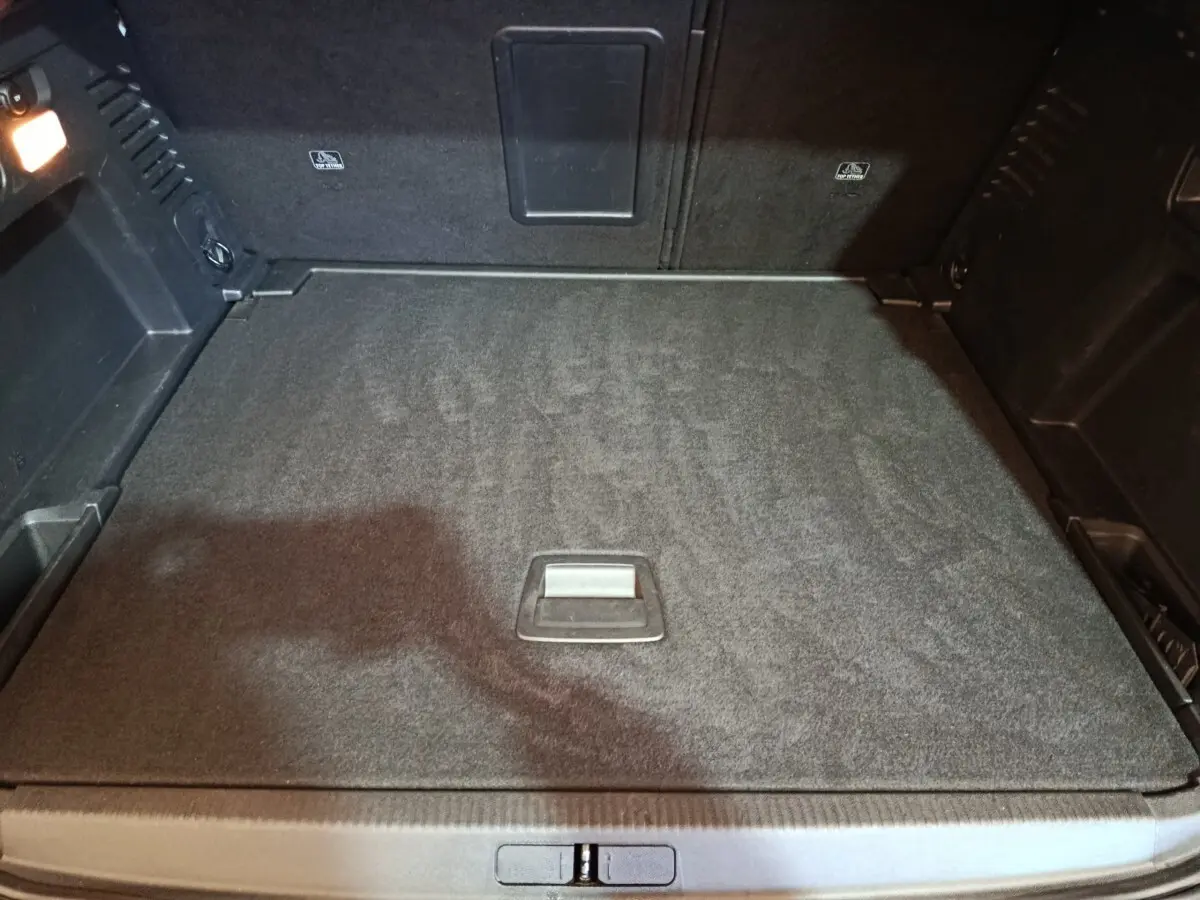 Vue intérieure du coffre spacieux et plat du Peugeot 3008 blanc, version Puretech 130 S&S EAT8 Allure, avec éclairage latéral.