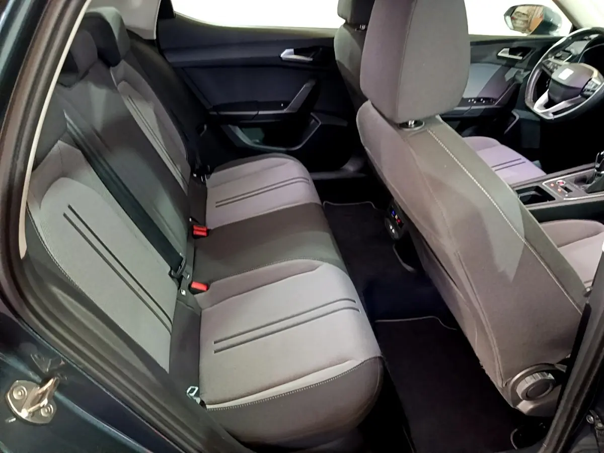 Vue intérieure côté gauche montrant la banquette arrière grise et les sièges avant du SEAT Leon 2023.
