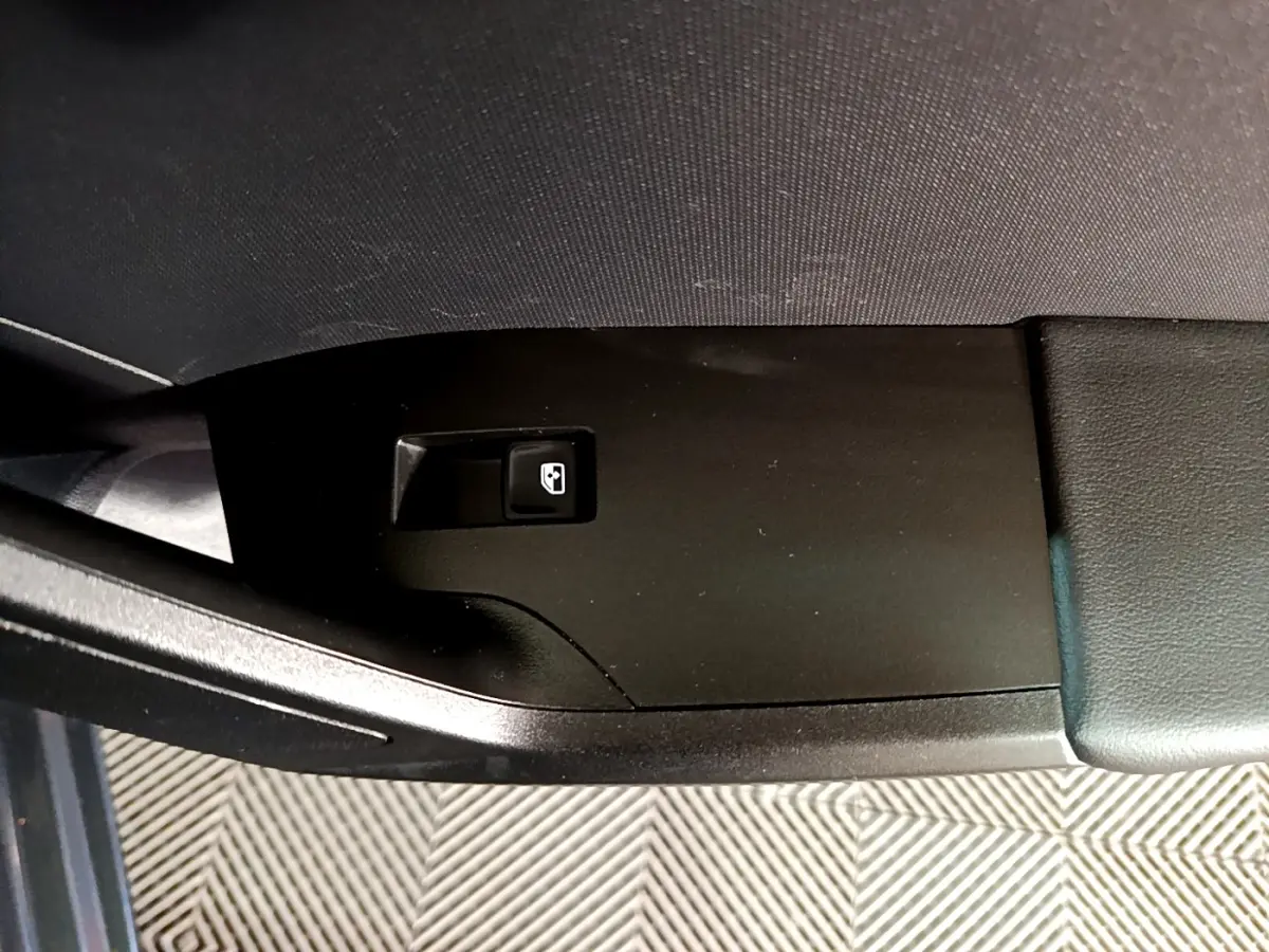 Gros plan sur le bouton de verrouillage centralisé sur la portière côté conducteur d'une SEAT Leon gris clair 2023.