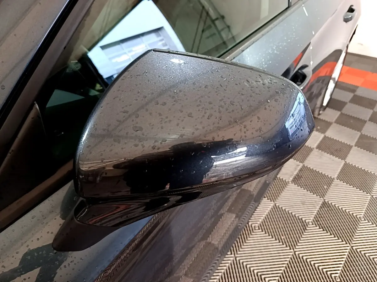 Rétroviseur droit gris clair de la SEAT LEON 2023, vue rapprochée avec gouttes d'eau sur la carrosserie.