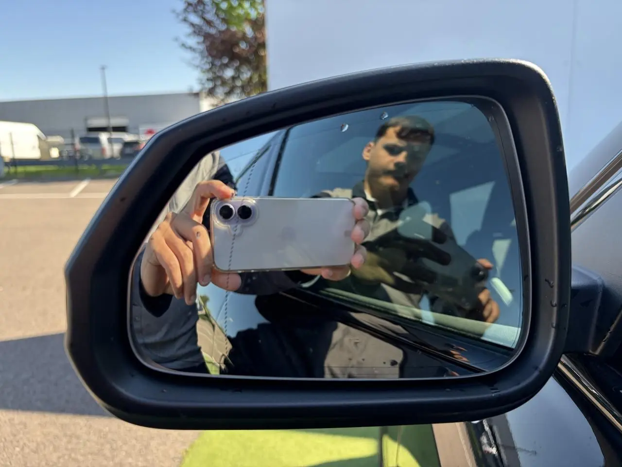 Rétroviseur extérieur droit noir d'une BMW X1 2025 noir saphir avec surface miroir et reflet partiel.