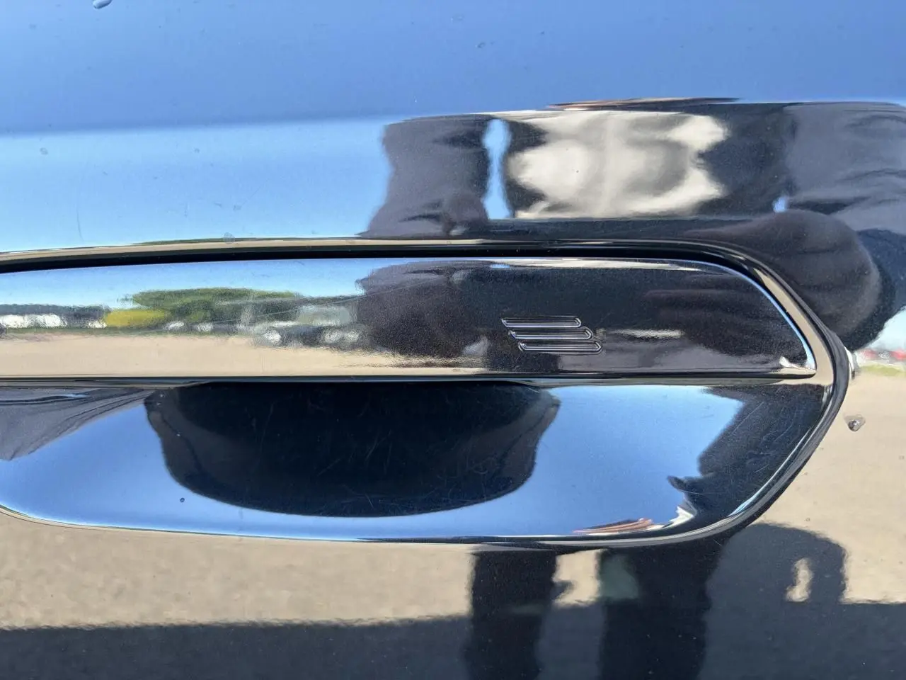 Poignée de porte noire Saphir en gros plan sur BMW X1 2025, reflet brillant et contours chromés visibles.