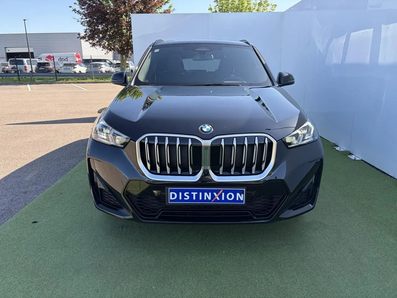 BMW X1 noir saphir vue de face, mettant en valeur la calandre imposante et les phares LED avancés.