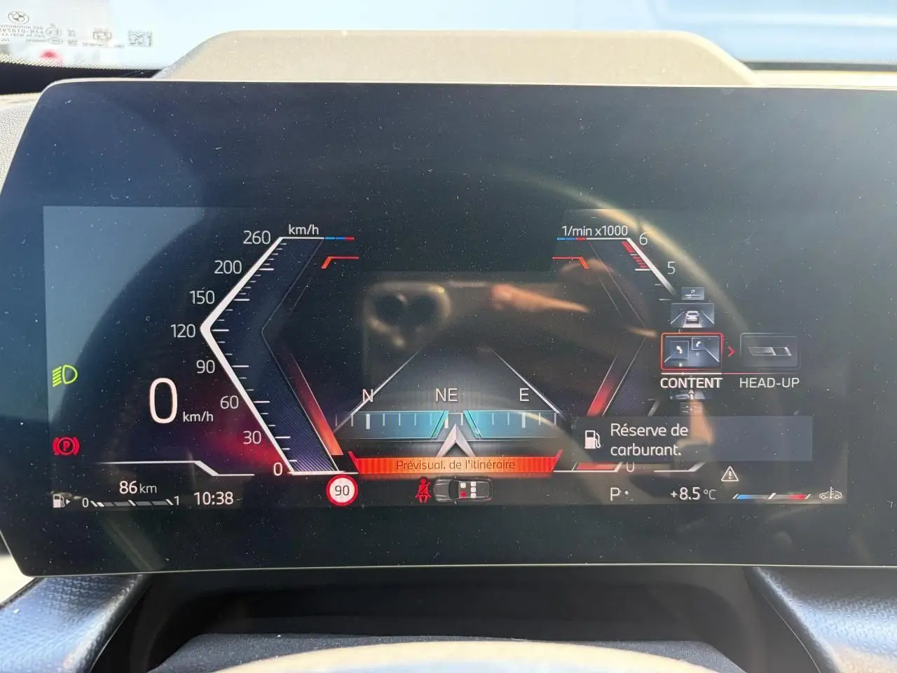 Affichage numérique du combiné d'instruments du BMW X1 noir, avec indication vitesse, navigation et alertes visibles.