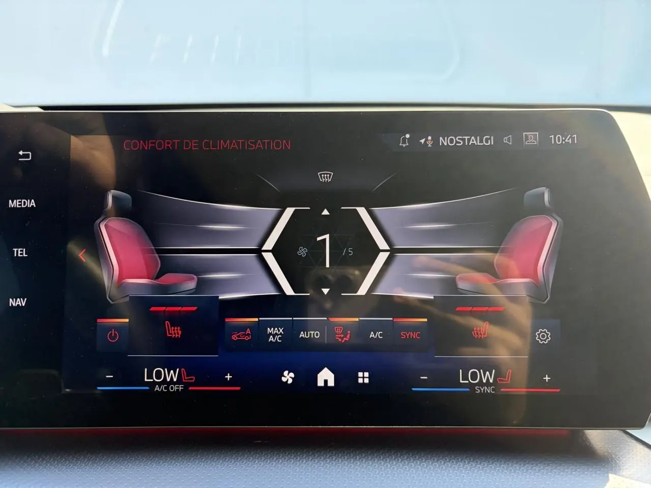 Écran tactile intérieur affichant le confort de climatisation avec sièges chauffants rouges sur BMW X1 noir saphir.