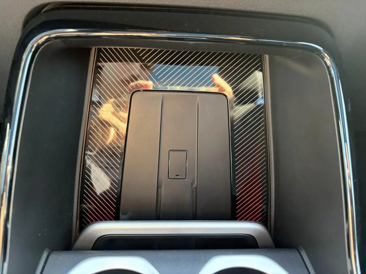 Détail de la console centrale du BMW X1 noir Saphir 2025, avec surface à motifs diagonaux et recharge par induction.
