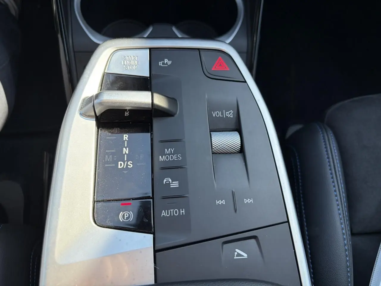 Gros plan sur la console centrale du BMW X1 noir Saphir, avec levier de vitesse et commandes multimédia visibles.