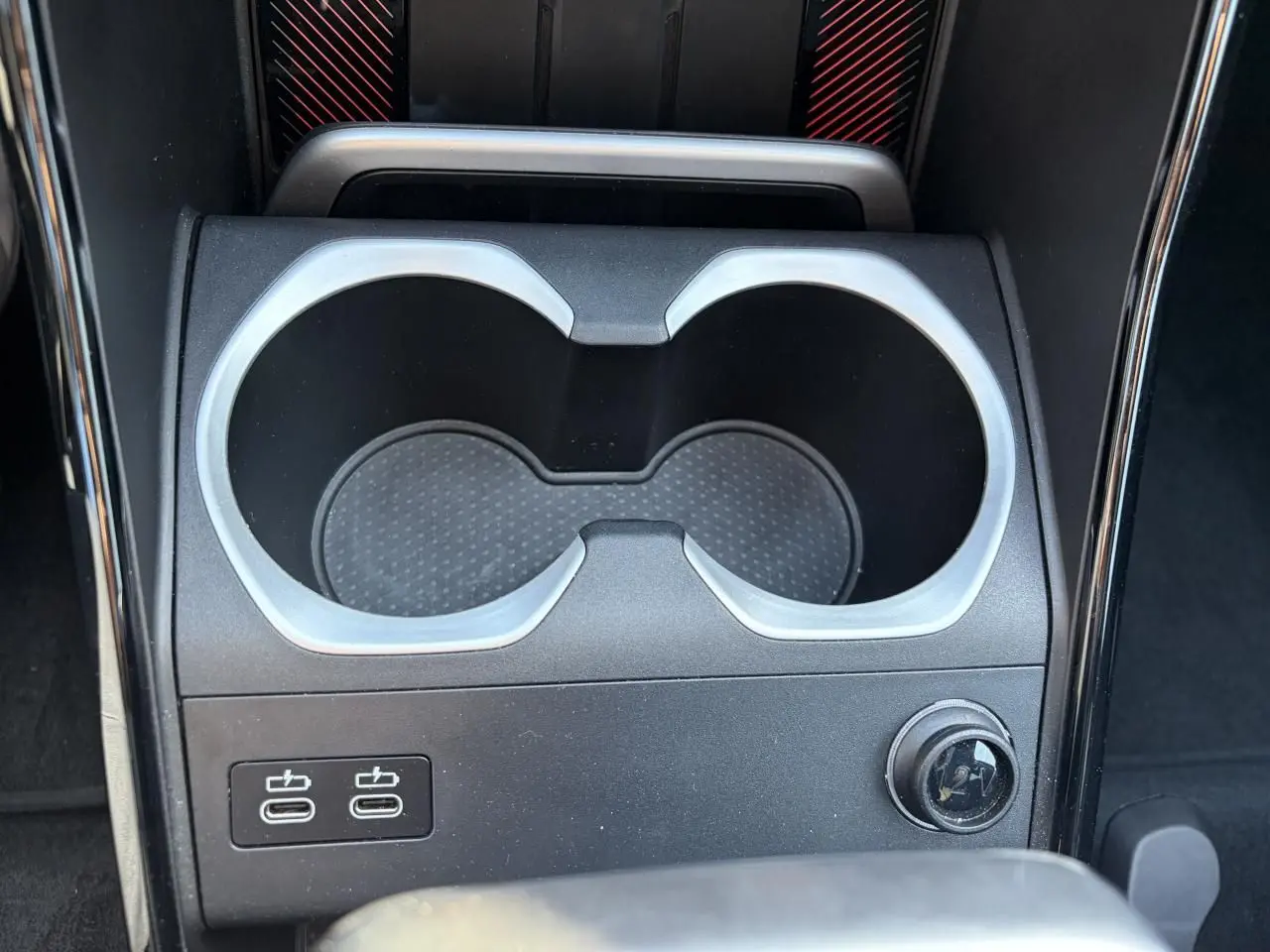 Gros plan sur la console centrale noire avec porte-gobelets et deux ports USB-C du BMW X1 noir Saphir 2025.