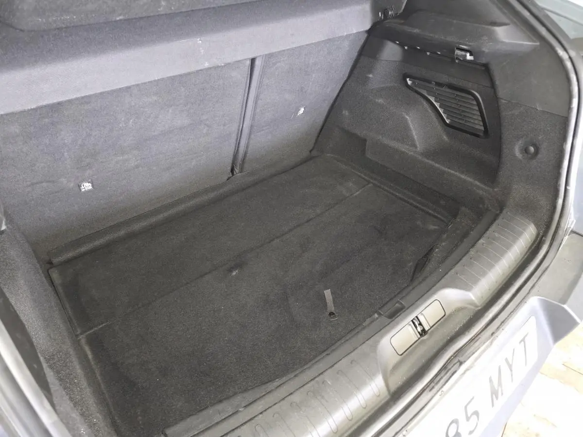 Coffre ouvert vu de dessus d'une Alfa Romeo Junior 1.2 Ibrida gris, montrant un espace de chargement propre et vide.