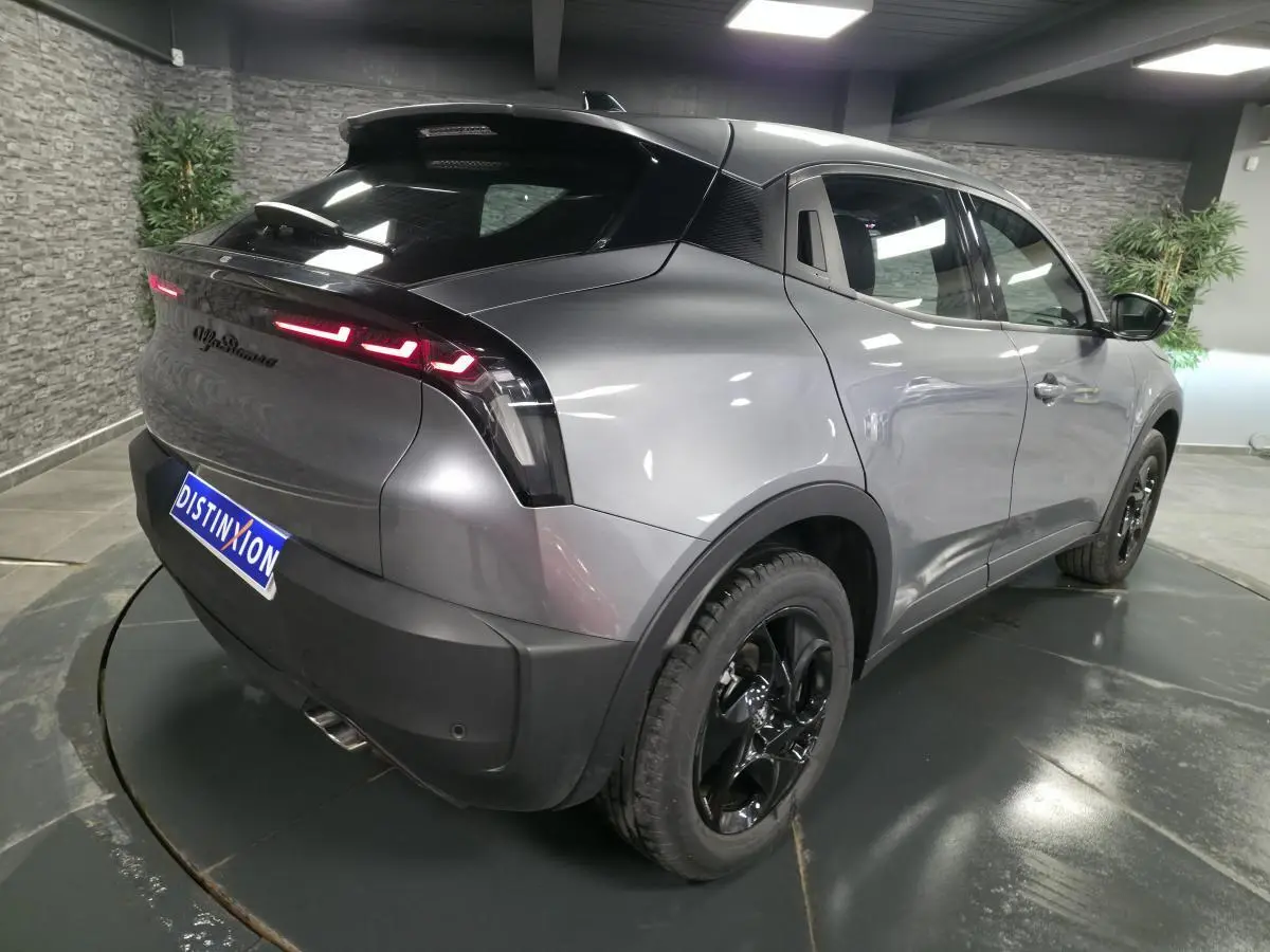 Vue 3/4 arrière droite de l'Alfa Romeo Junior gris métallisé avec feux arrière LED et jantes alliage noires.