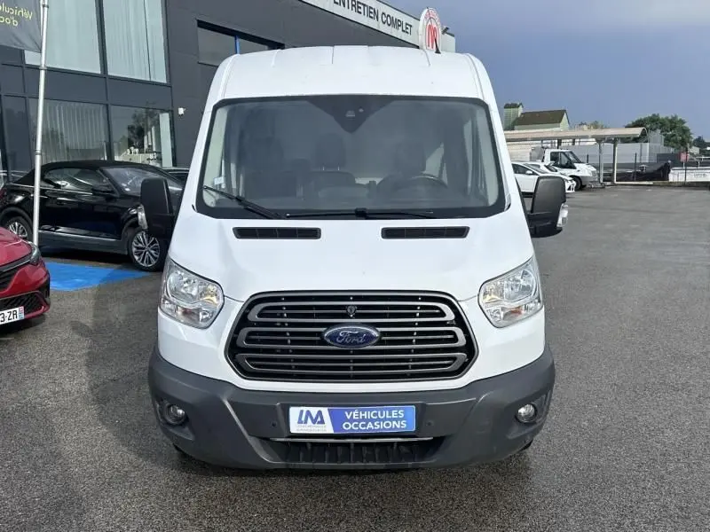 Vue avant d’un fourgon Ford Transit blanc 2019 avec calandre noire et plaque « Véhicules Occasions » visible.