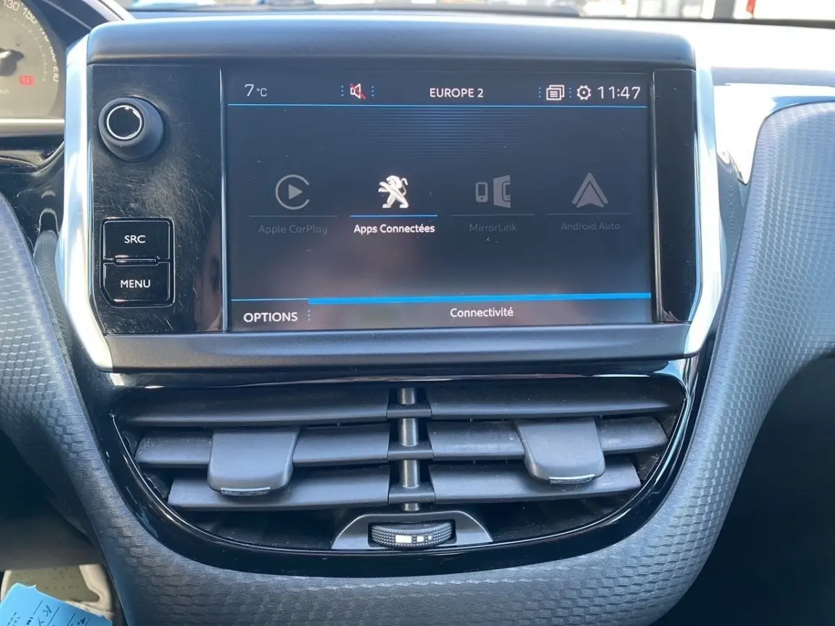 Vue rapprochée de l’écran tactile central du tableau de bord du Peugeot 2008 gris foncé, affichant les apps connectées.