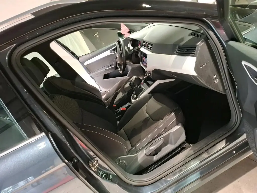 Intérieur du SEAT Arona gris foncé 2021 vu côté conducteur, avec tableau de bord clair et sièges noirs.