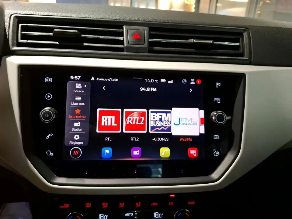 Vue rapprochée de l’écran tactile multimédia du SEAT Arona gris foncé, affichant les stations radio FM.