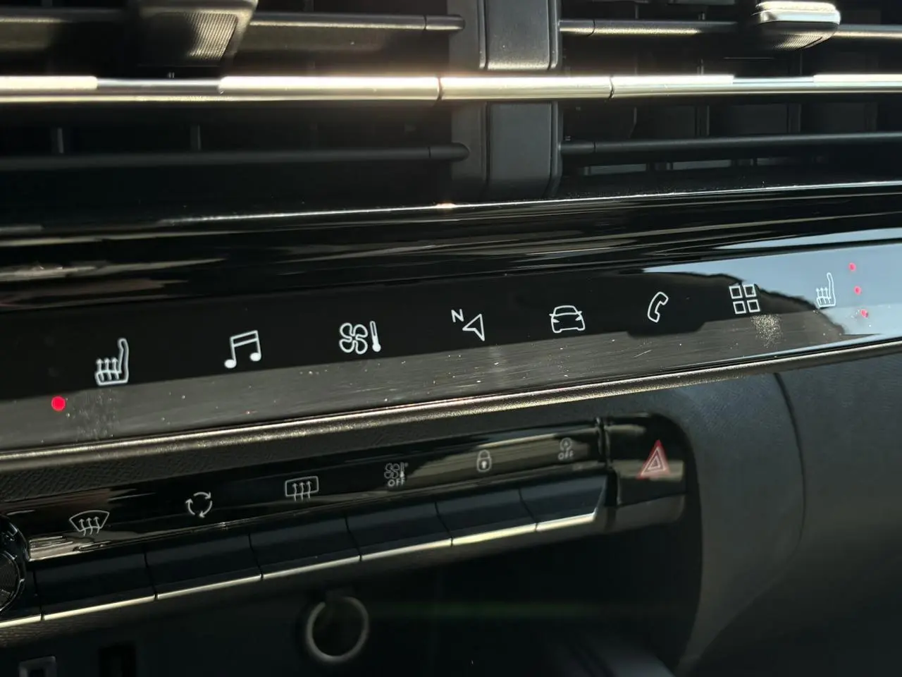 Détail du tableau de bord noir brillant de la Citroën C5 Aircross Hybrid avec commandes tactiles et sièges chauffants activés.