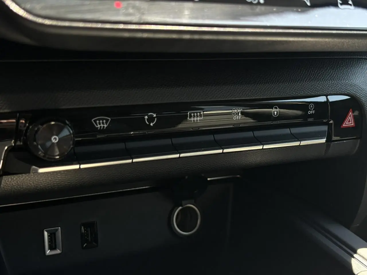 Détail de la console centrale noire du Citroën C5 Aircross Hybrid 2025 avec commandes climatisation et ports USB visibles.