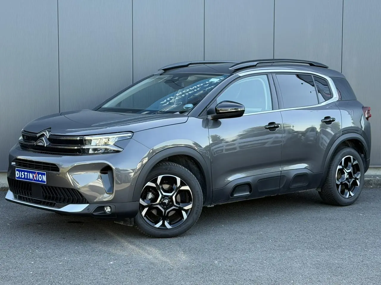 Citroën C5 Aircross Hybrid gris Platinium en 3/4 avant droit, avec jantes bi-ton et protections latérales noires.