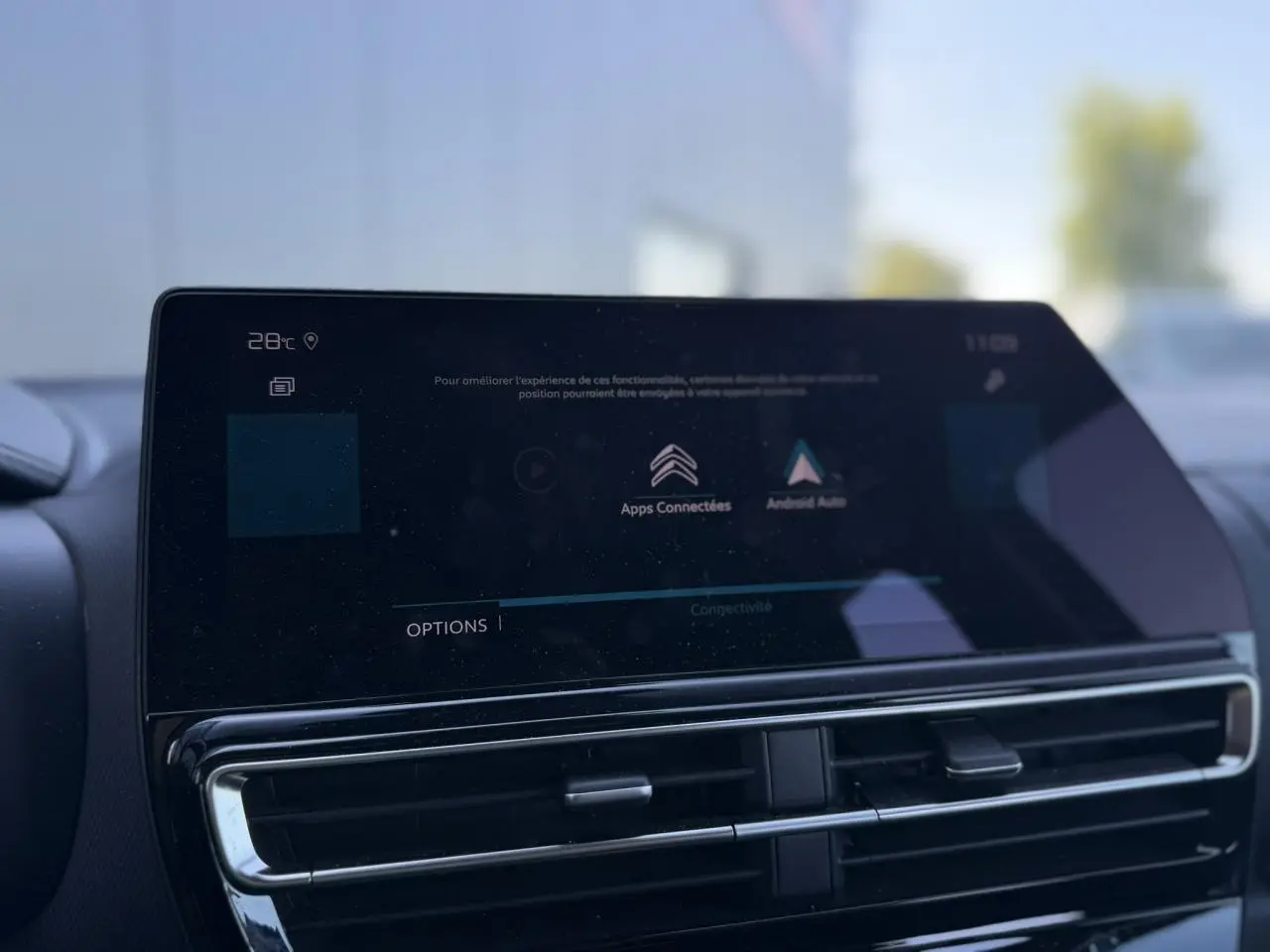 Gros plan sur l'écran tactile central et les aérateurs noirs brillants du tableau de bord du Citroën C5 Aircross Hybrid.