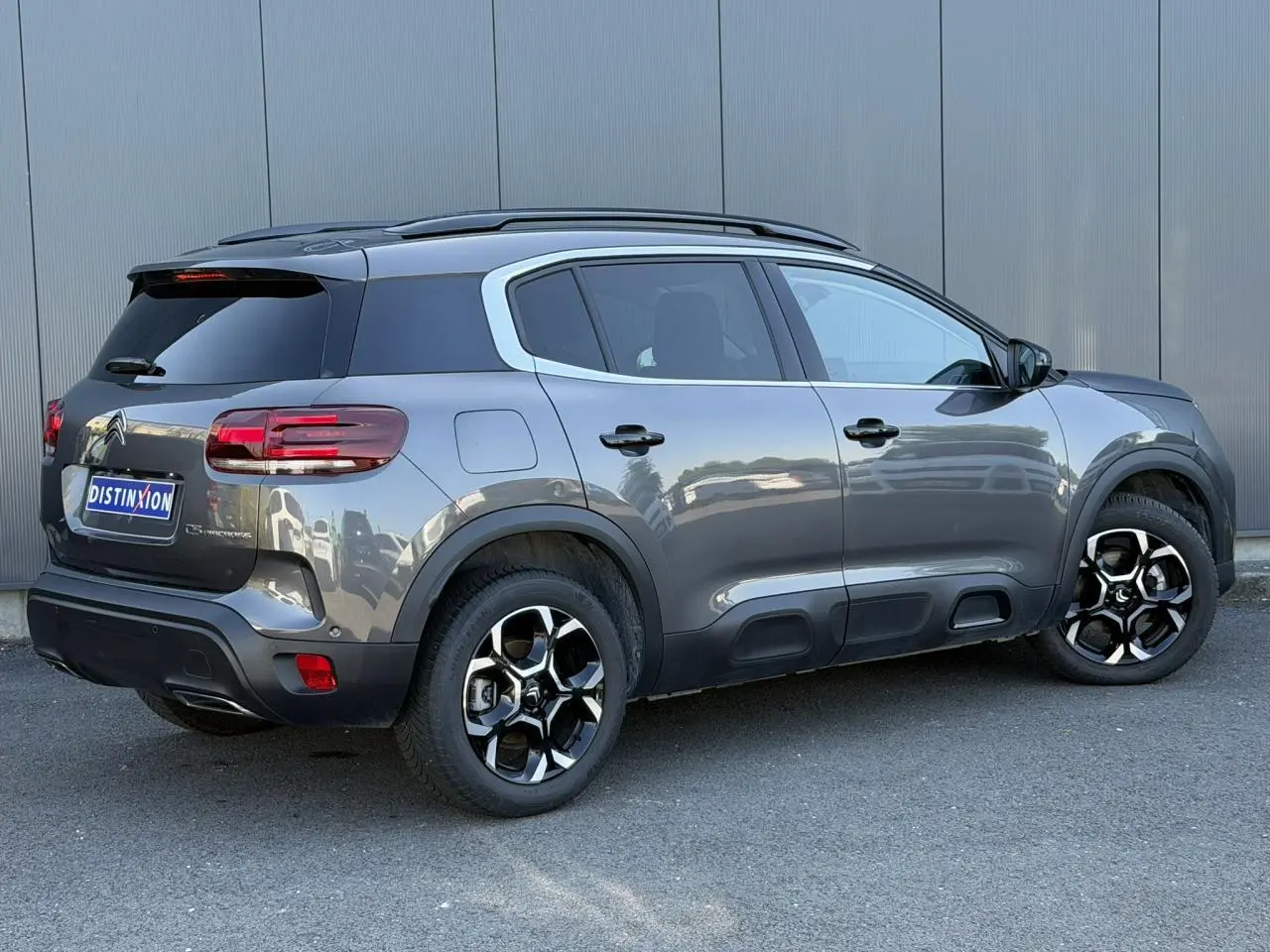 Vue 3/4 arrière droite du Citroën C5 Aircross Hybrid gris Platinium avec jantes bi-ton et toit noir.