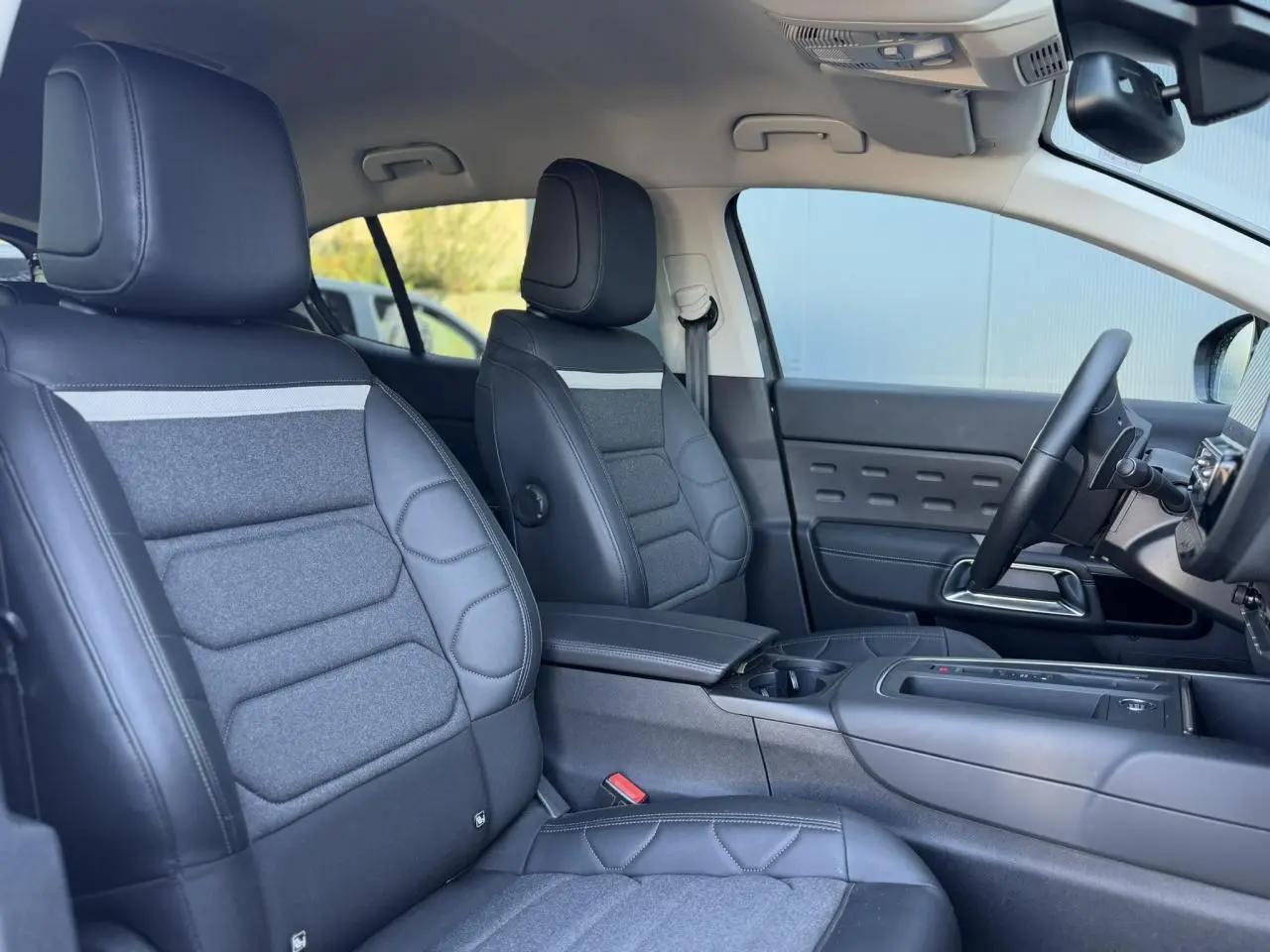 Vue intérieure côté droit du Citroën C5 Aircross Hybrid 2025, sièges Advanced Comfort en cuir et tissu gris foncé.