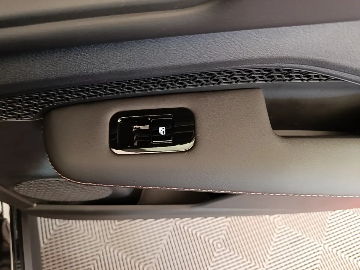 Détail de la commande de lève-vitre sur la porte intérieure noire du Nissan Ariya 63kWh 218ch Engage 2026.