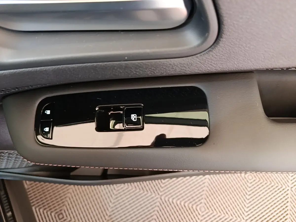 Détail de la commande de lève-vitre électrique sur la porte côté conducteur du Nissan Ariya noir 2026.