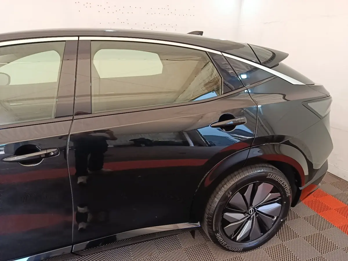 Vue côté droit arrière du Nissan Ariya noir 63kWh 218ch Engage avec jante stylisée et poignées de porte intégrées.