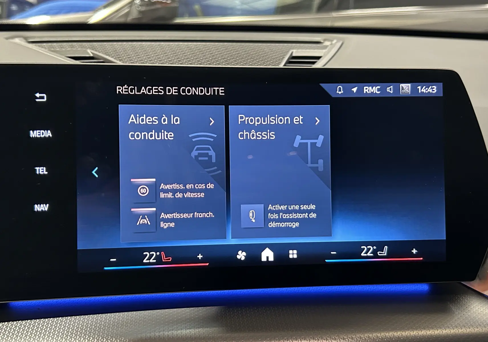 Écran tactile central du BMW X1 2024 affichant les réglages de conduite avec interface moderne et éclairage d'ambiance bleu