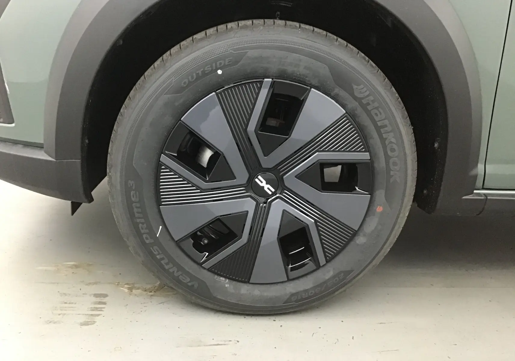 Gros plan sur la roue avant gauche de la Dacia Sandero Stepway 2025 kaki avec jante noire au design moderne.