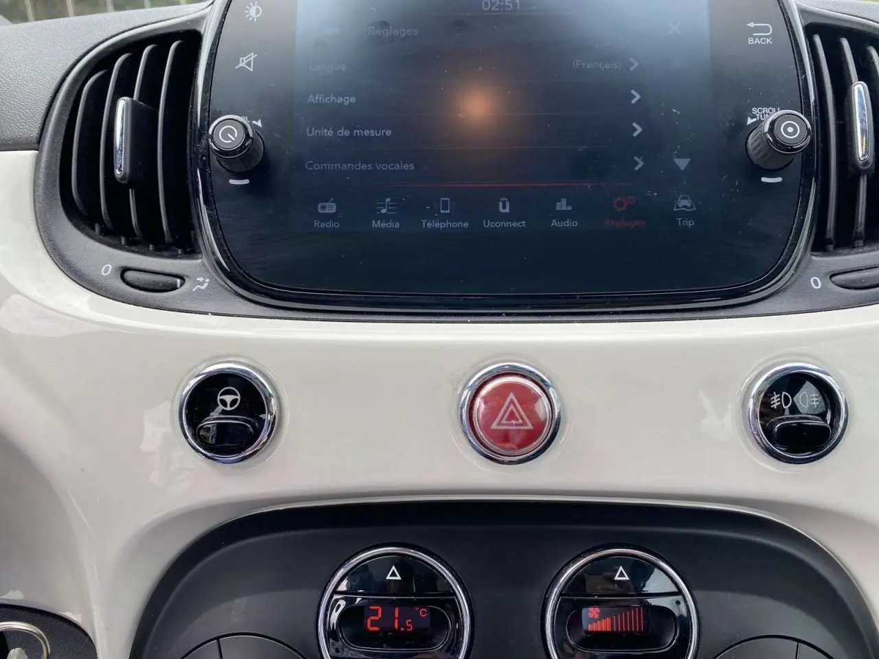 Tableau de bord blanc de la Fiat 500 2024 avec écran tactile et commandes climatisation affichant 21,5°C.
