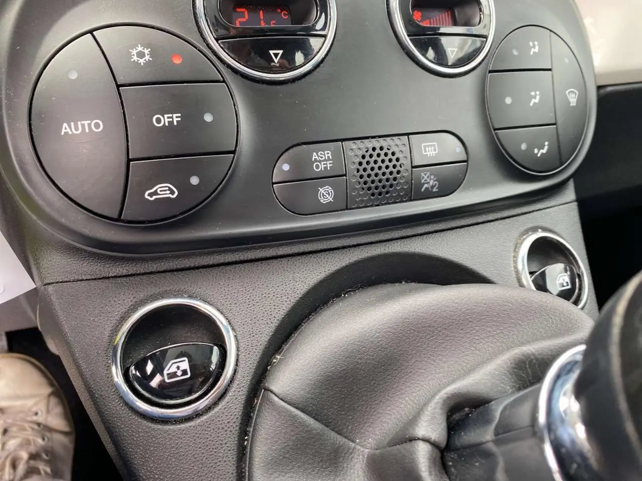 Gros plan sur la console centrale et commandes de climatisation de la Fiat 500 blanche 2024, avec boutons ronds noirs.