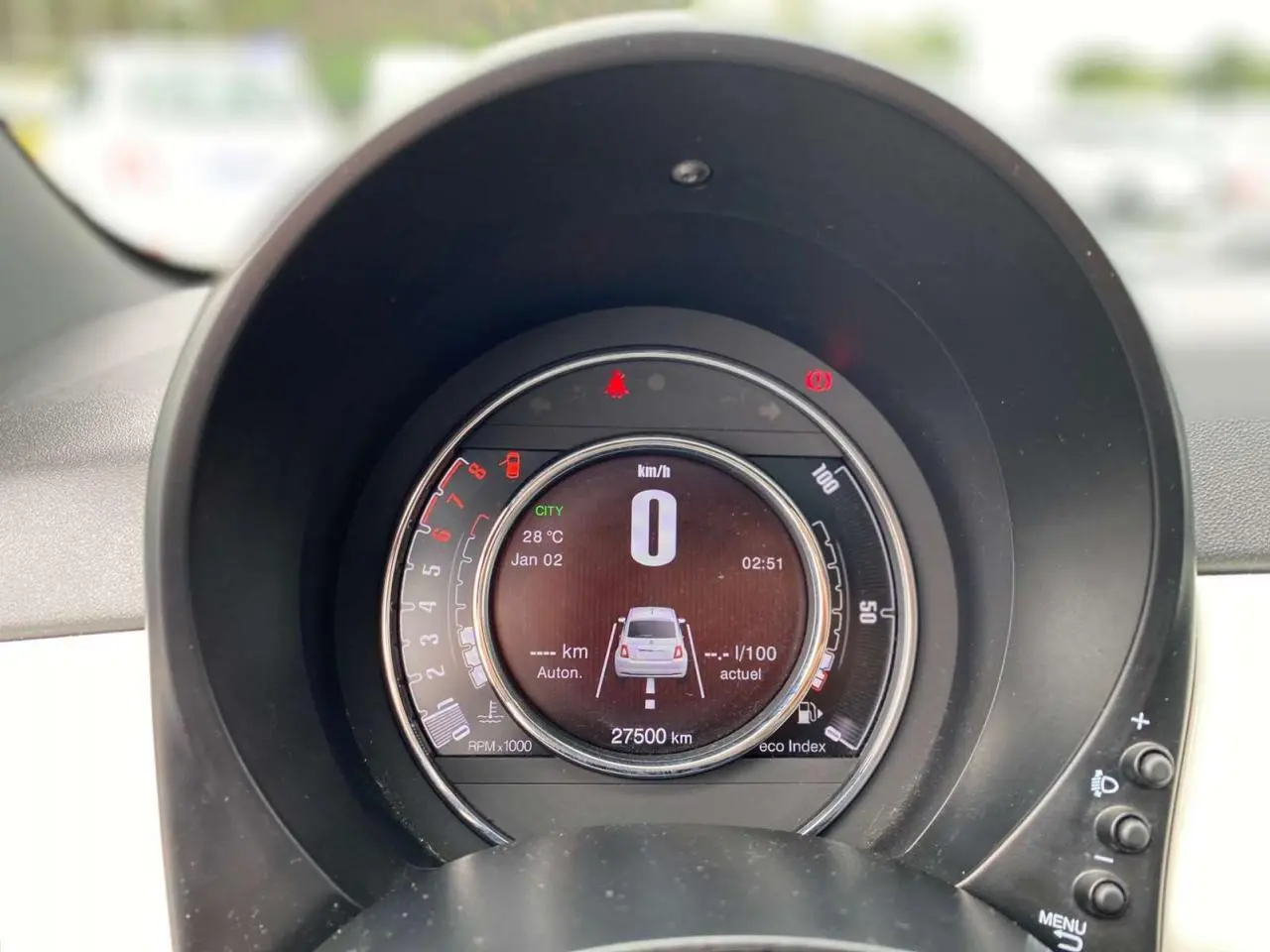 Vue rapprochée du tableau de bord numérique de la Fiat 500 blanche 2024 affichant la vitesse et l'autonomie.