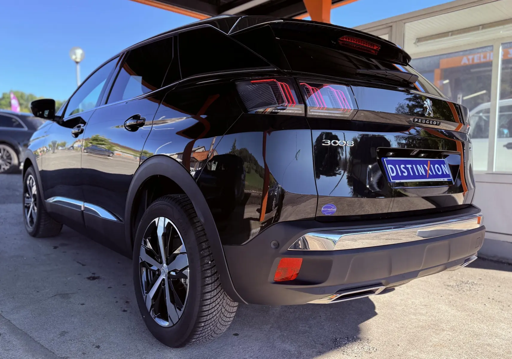 Vue 3/4 arrière droite d'un Peugeot 3008 noir perle métal avec feux arrière LED et jantes alliage.