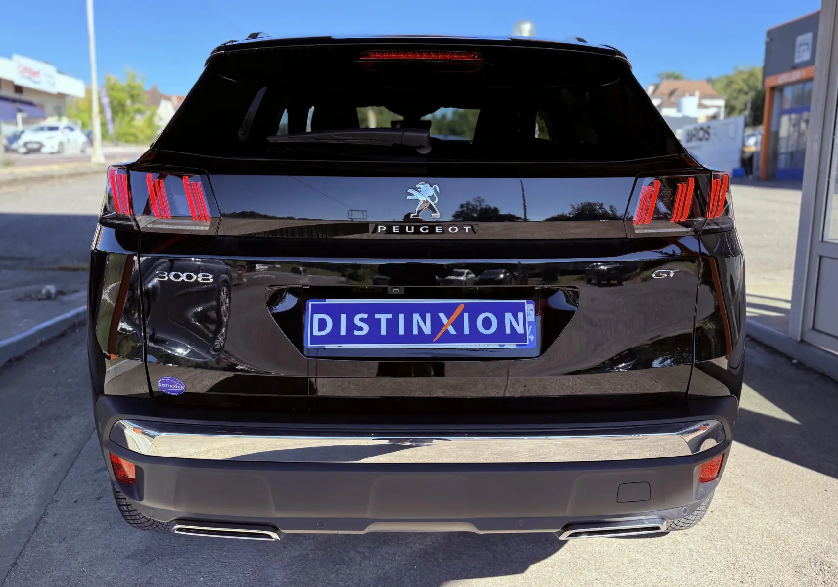 Vue arrière d'un Peugeot 3008 noir perle métal avec feux arrière à griffes rouges et logo GT visible.